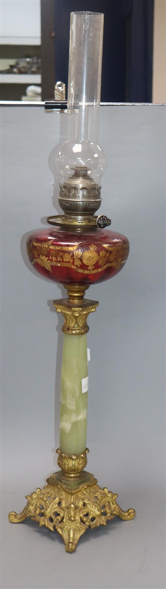 An ormolu and onyx oil lamp with cranberry reservoir
